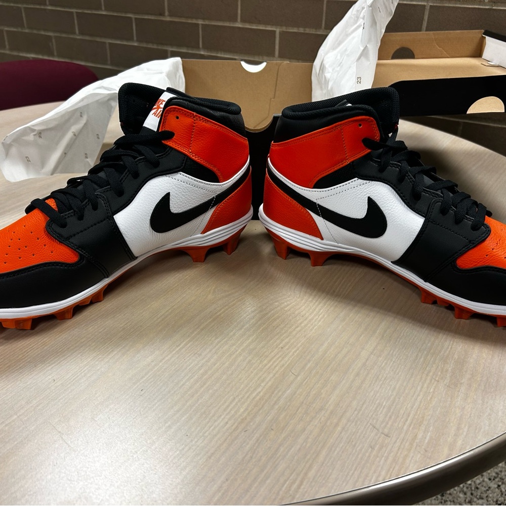 Nike Black, White, and Orange High-Top Cleats